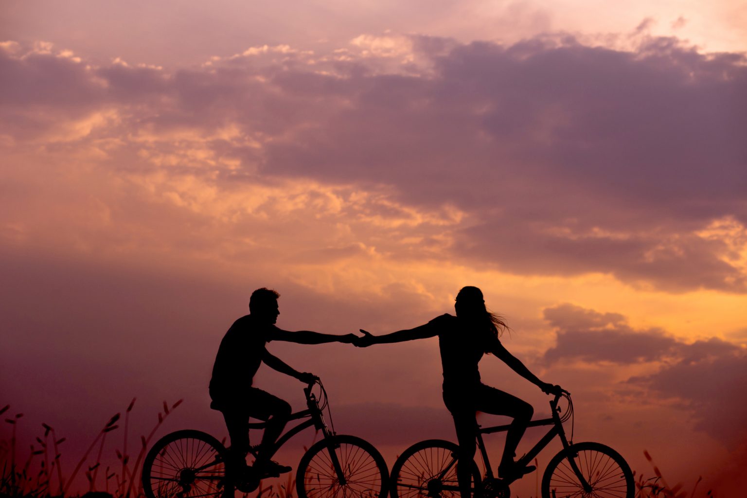 silhouette of a couple riding bikes