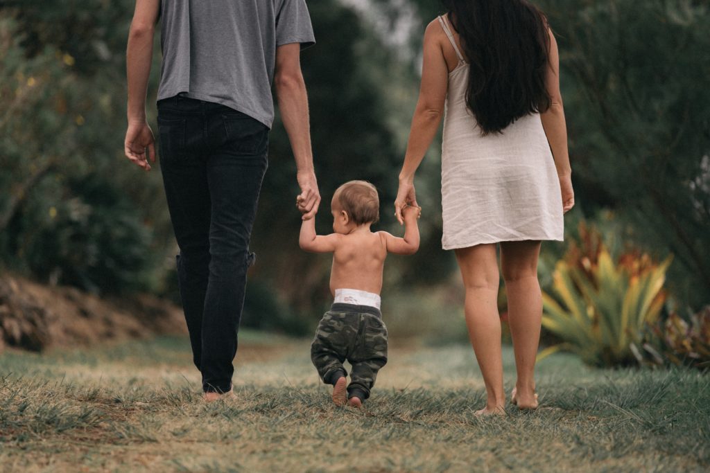 a man and woman walking with a baby