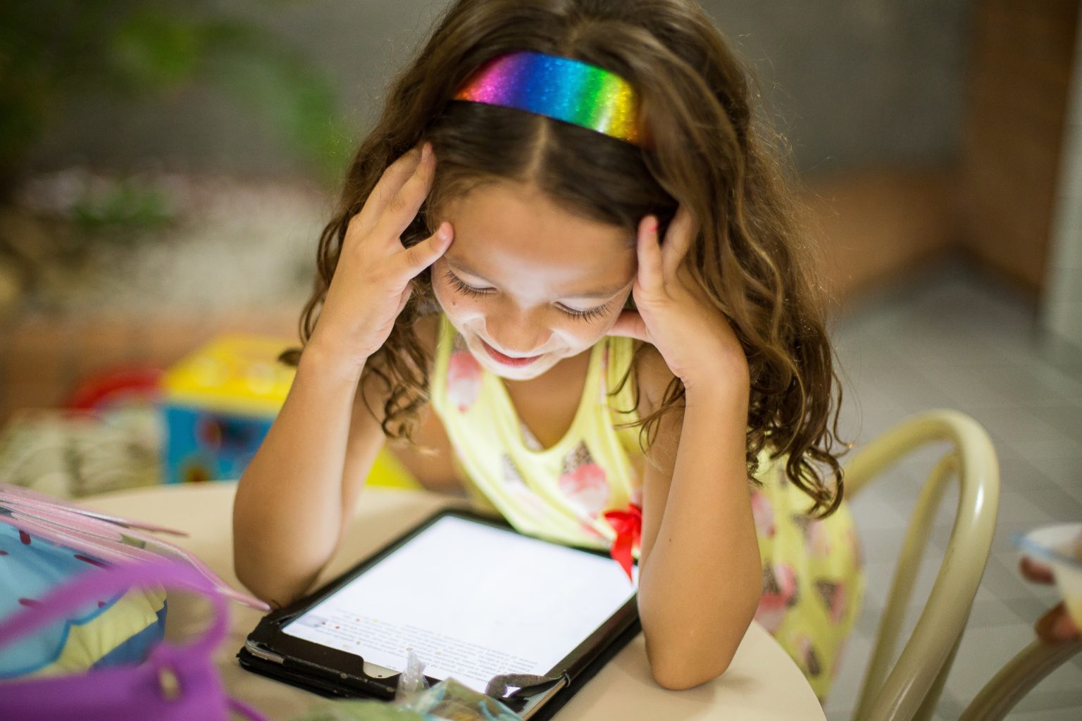 a young girl looking at a tablet