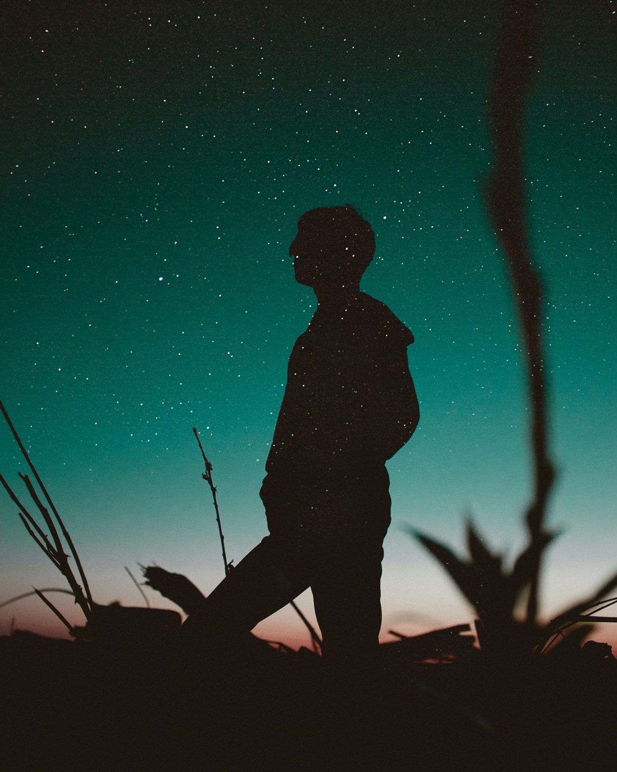 a man standing in front of a starry night sky