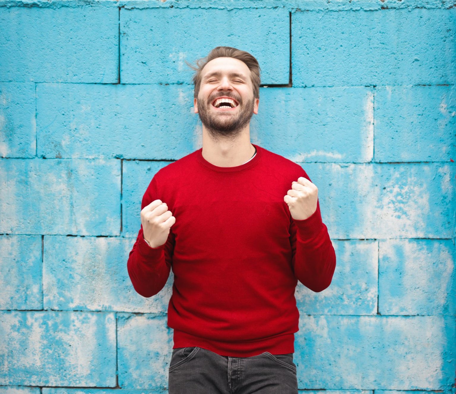 a man smiling with his arms crossed