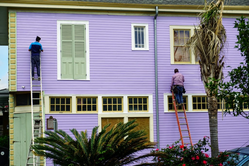 men standing on a ladder outside a building