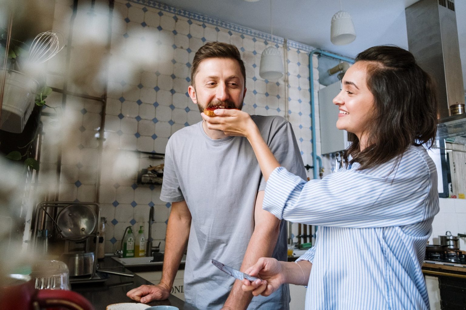 a man and woman standing in a kitchen